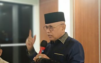 Darmizal memberikan pernyataan soal video Saiful Mujani sambil berbicara menggunakan mikrofon di dalam ruangan.