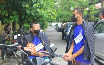 Tersangka memperagakan rekonstruksi pembunuhan di Bantul dengan barang bukti senjata tajam di lokasi kejadian.