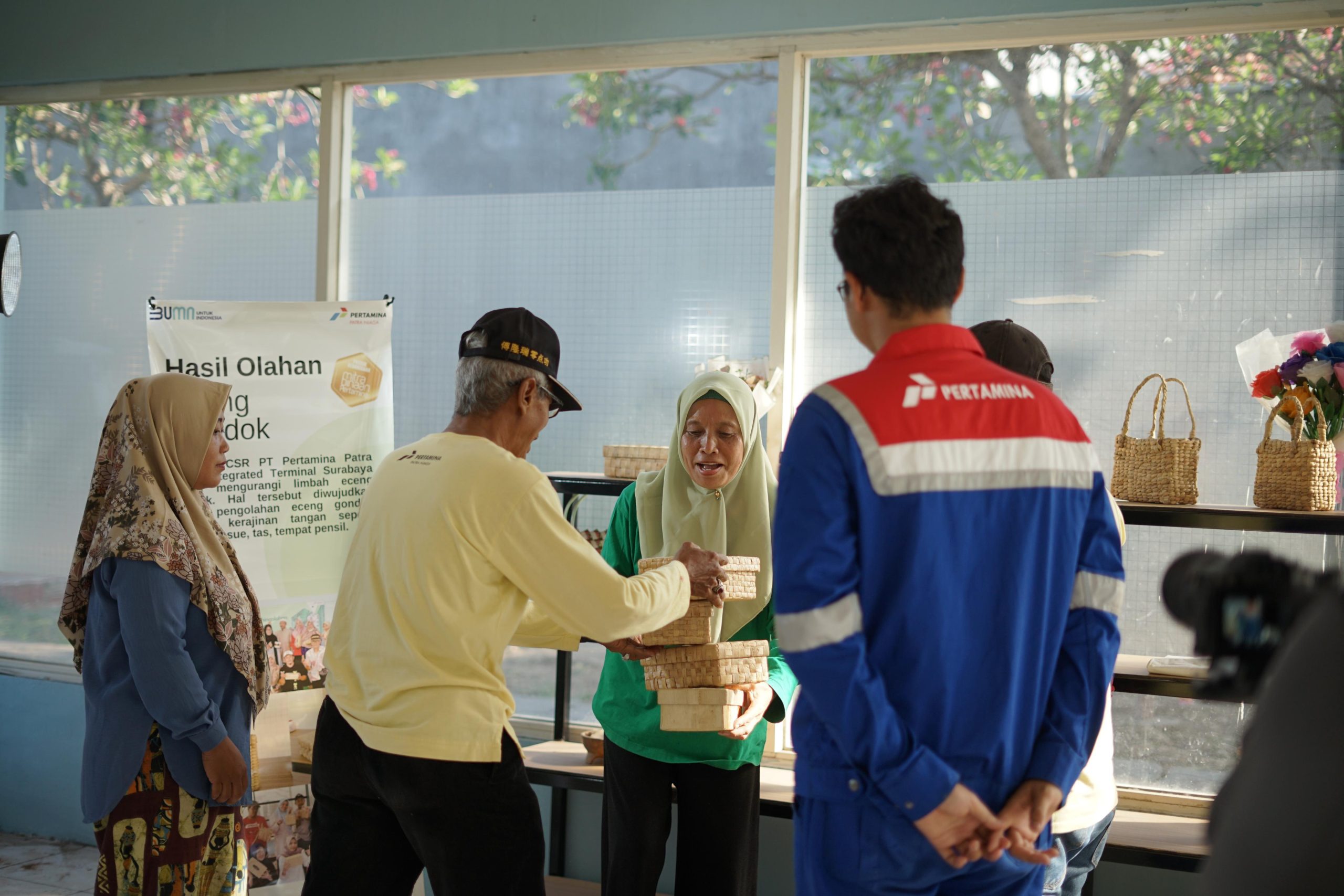 Warga memperlihatkan produk kerajinan dari eceng gondok dalam program lingkungan Pertamina Patra Niaga di Surabaya.