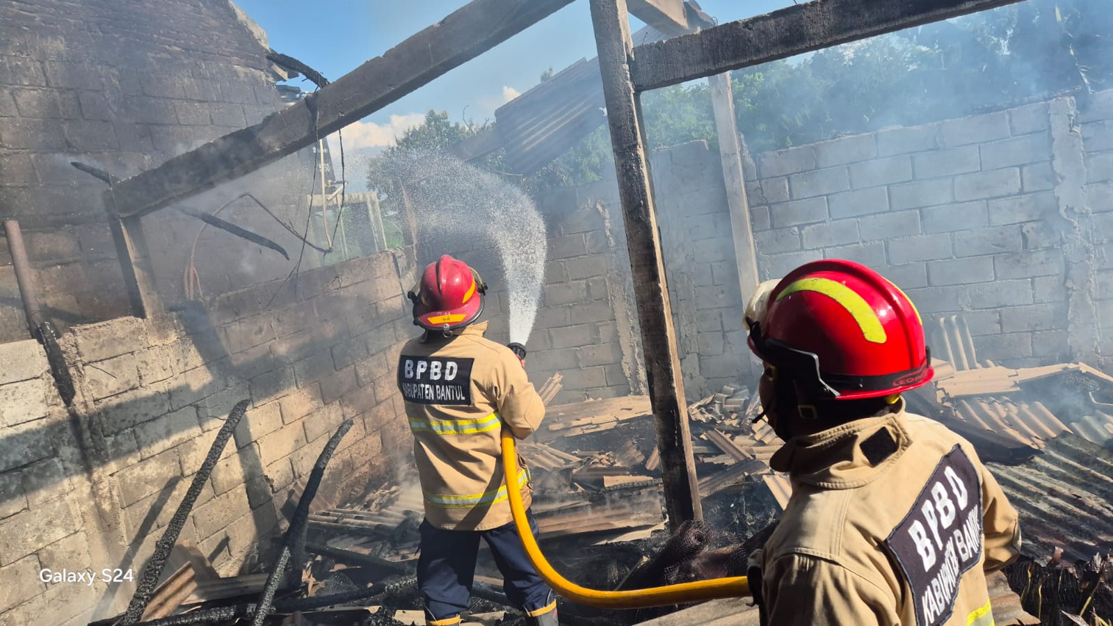 Petugas pemadam kebakaran memadamkan kebakaran bekas kandang puyuh di Berbah, Sleman.