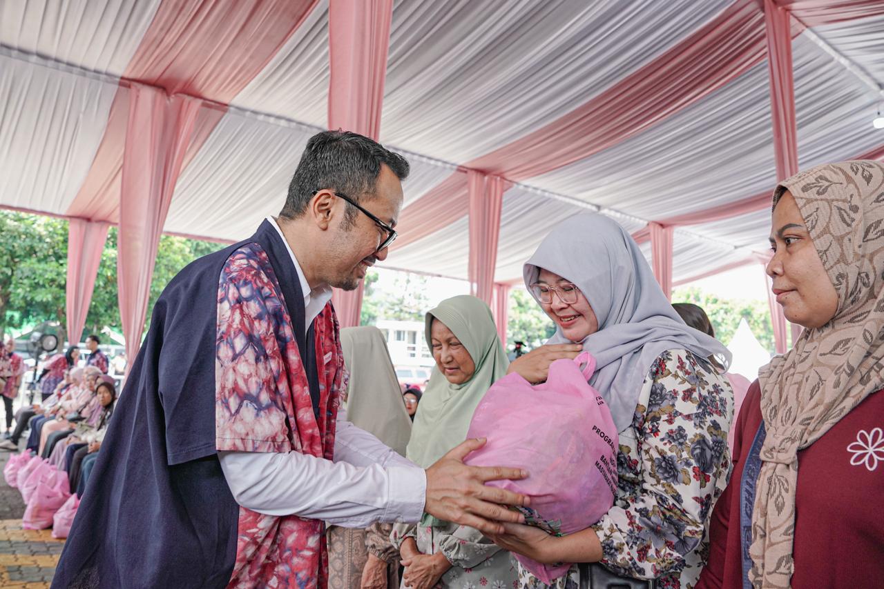 Perwakilan Pertamina menyerahkan paket sembako kepada warga dalam kegiatan pasar murah Hari Kartini