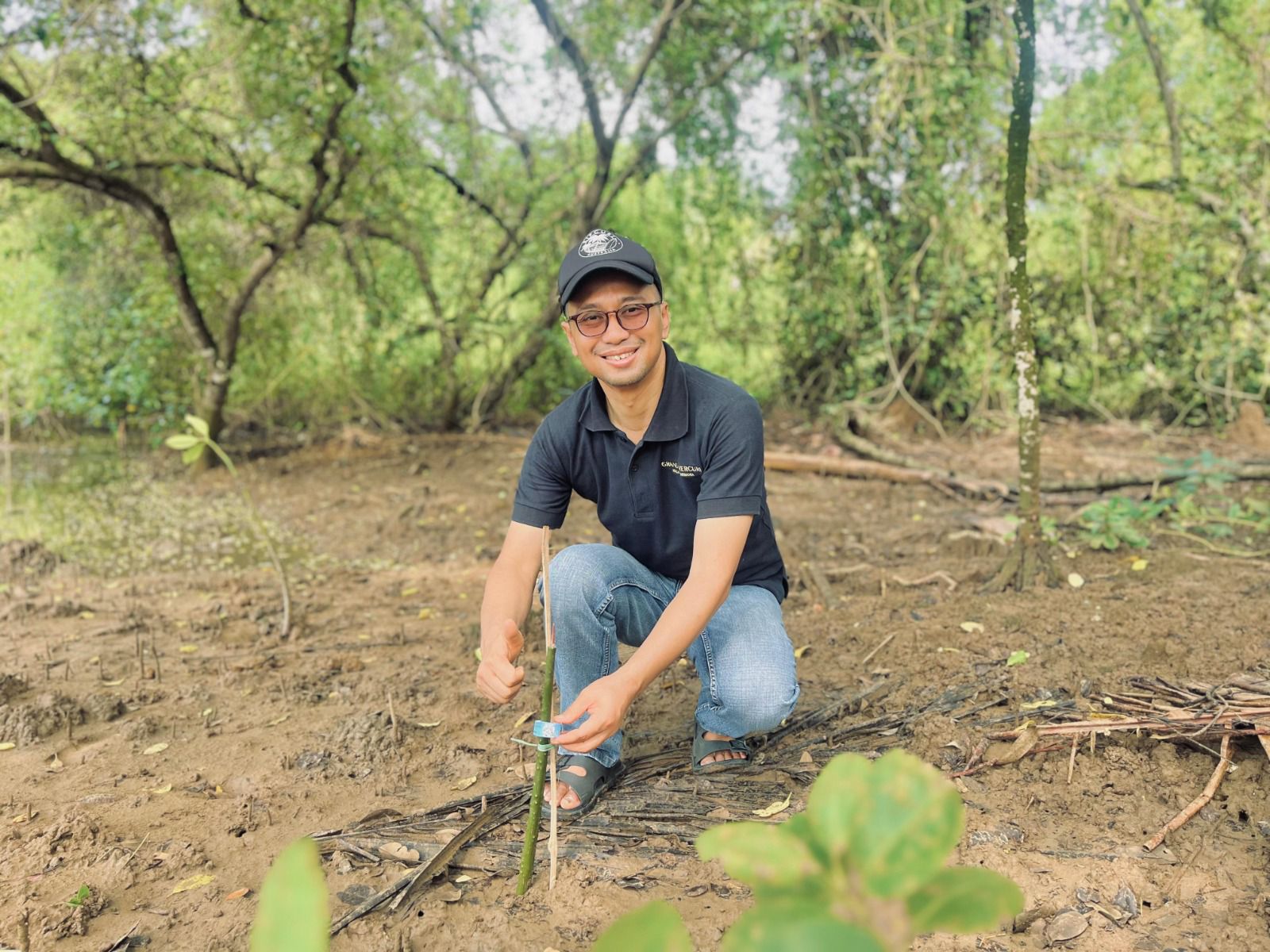 Seorang peserta menanam bibit mangrove di kawasan pesisir Pantai Tamban Malang dalam kegiatan Hari Bumi 2026