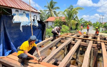 polisi dan warga membangun jembatan merah putih barito kuala pemasangan kayu ulin