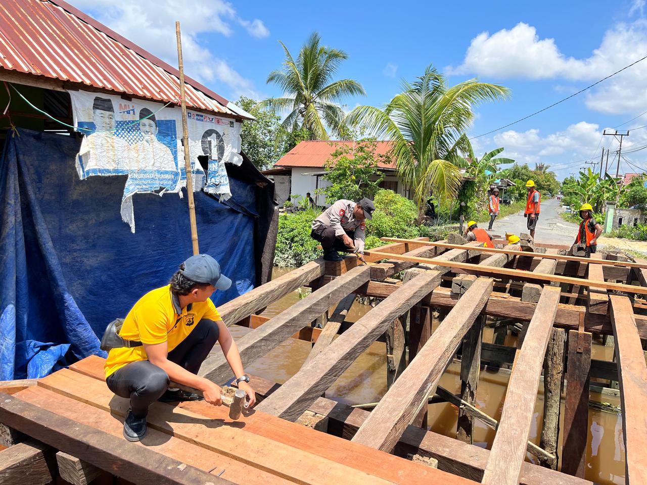 polisi dan warga membangun jembatan merah putih barito kuala pemasangan kayu ulin