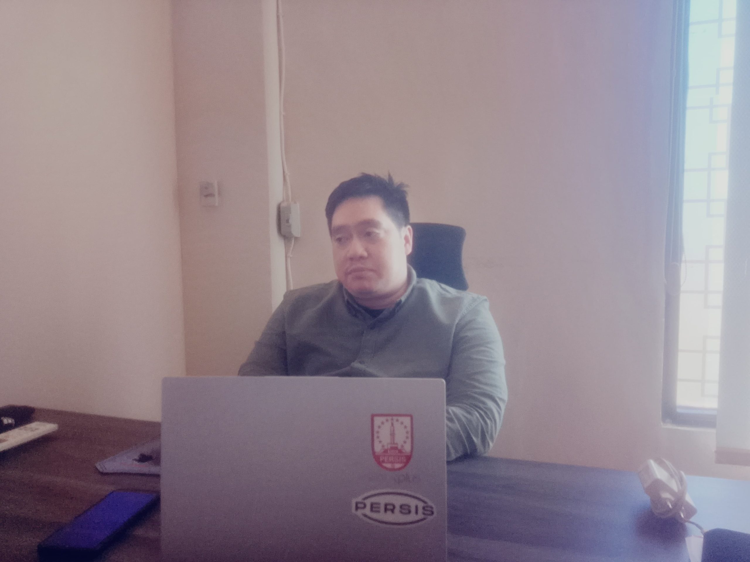 Seorang pejabat Kantor Pertanahan Kotabaru duduk di depan laptop saat memberikan penjelasan mengenai digitalisasi data tanah di dalam ruangan kantor.