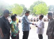 Wakil Bupati Pulang Pisau berjabat tangan dengan petani saat penyerahan bantuan hand tractor di halaman kantor dinas pertanian.