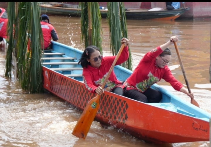 Peserta lomba Besei Kambe mendayung perahu dengan posisi saling membelakangi di Sungai Kapuas.