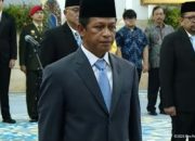 Hanif Faisol Nurofiq mengenakan setelan jas dan peci hitam saat prosesi pelantikan sebagai Wamenko Pangan di Istana Negara.