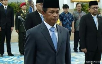 Hanif Faisol Nurofiq mengenakan setelan jas dan peci hitam saat prosesi pelantikan sebagai Wamenko Pangan di Istana Negara.