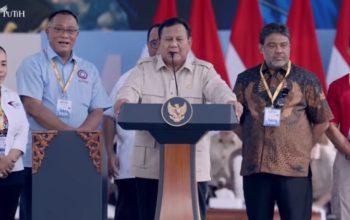 Presiden Prabowo Subianto berpidato di podium pada peringatan Hari Buruh 2026 di Monas, Jakarta, didampingi sejumlah pejabat dan perwakilan buruh.
