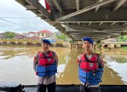 Dua anggota polisi perairan berjaga di Sungai Nagara Amuntai di bawah jembatan saat pengamanan balap jukung HSU