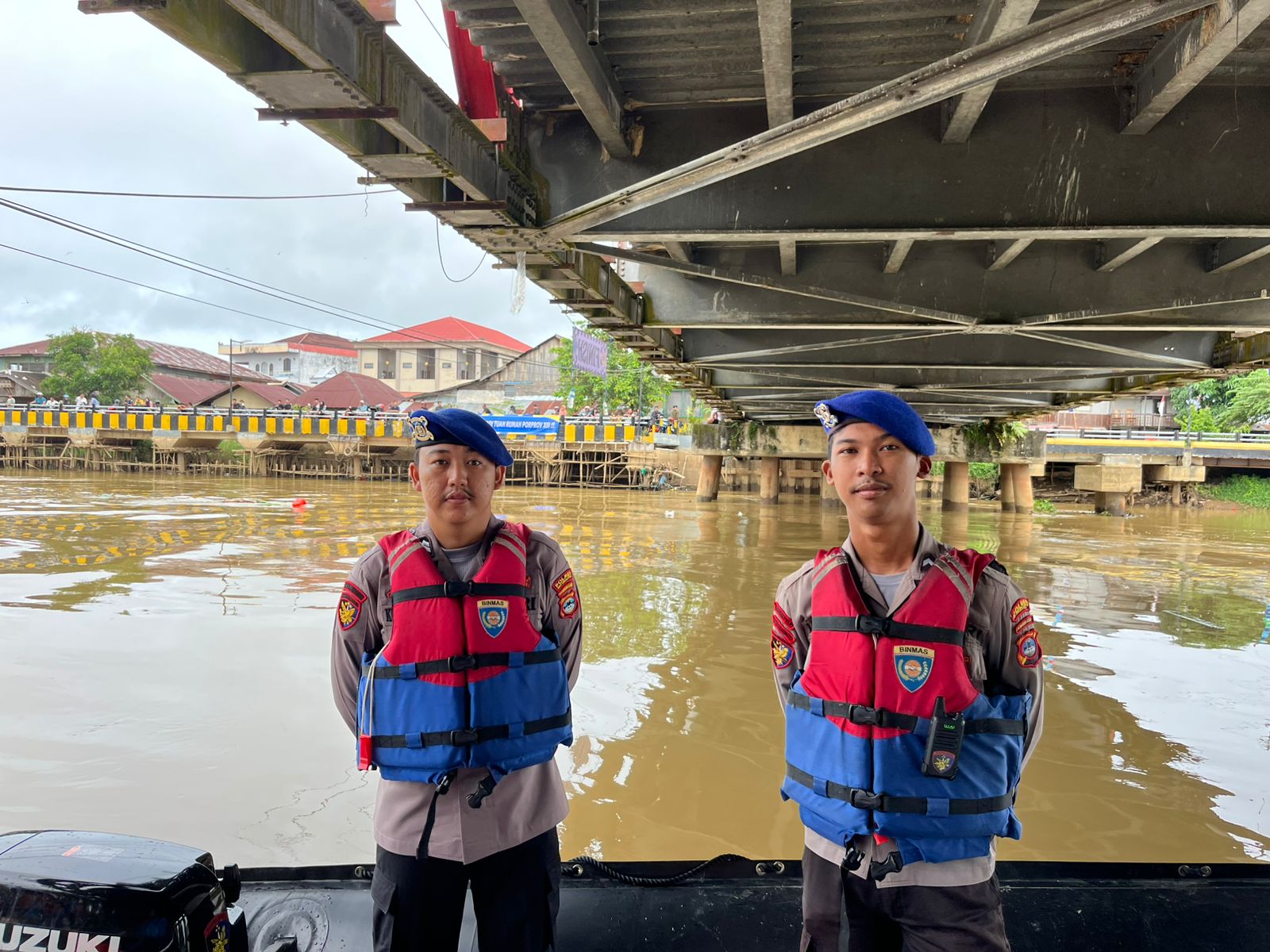 Dua anggota polisi perairan berjaga di Sungai Nagara Amuntai di bawah jembatan saat pengamanan balap jukung HSU