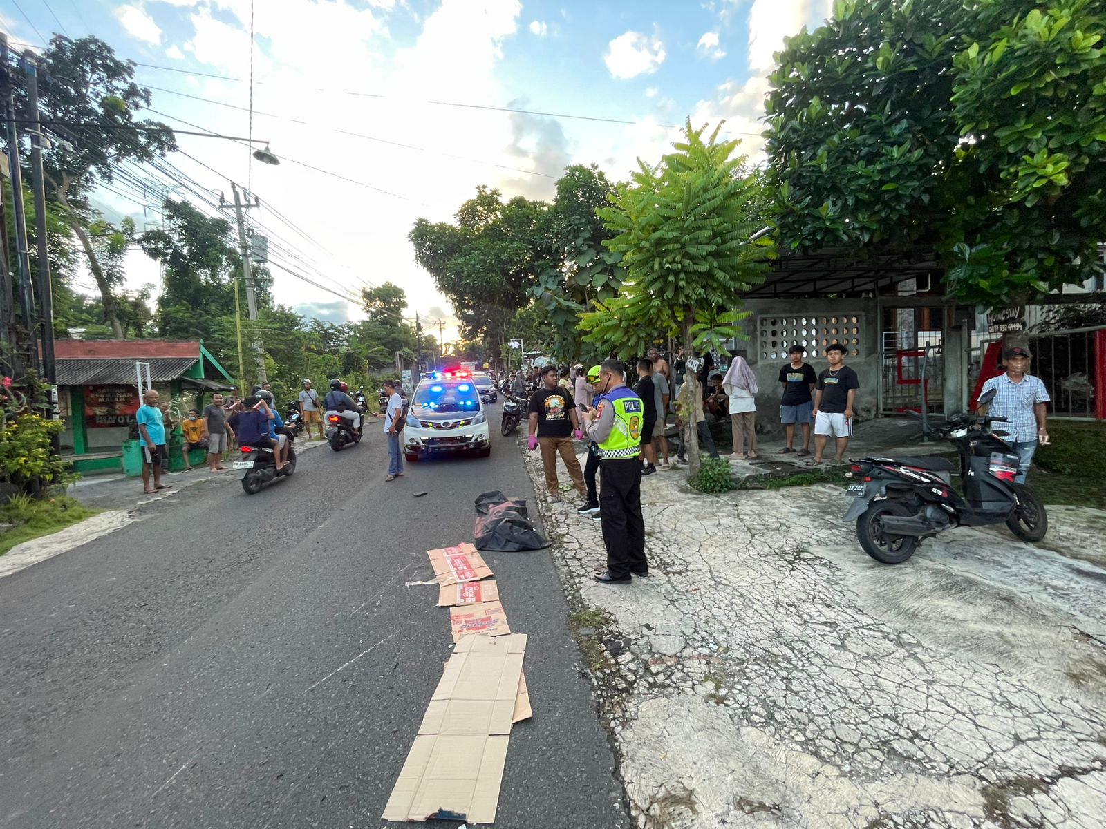 Polisi dan warga berada di lokasi kecelakaan lalu lintas di Bantul dengan korban pengendara motor meninggal dunia di pinggir jalan.
