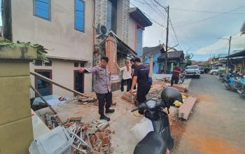 Polisi dan warga memeriksa lokasi rumah amblas di Banjarmasin Utara dengan puing bangunan terlihat di depan rumah.