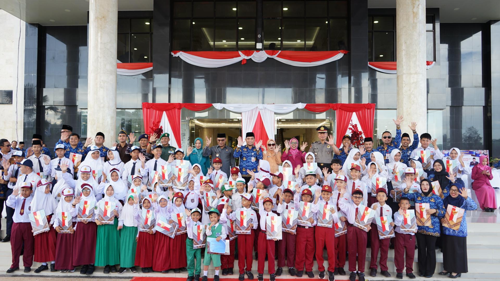 Siswa SD dan pejabat Pemkab Kotabaru berfoto bersama saat peringatan Hardiknas 2026 di depan Kantor Bupati.