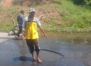 Warga memperlihatkan jalan berlubang dan tergenang air di Pal 6 Desa Sigam, Kotabaru.