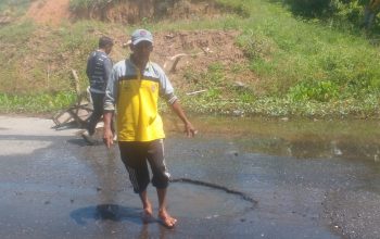Warga memperlihatkan jalan berlubang dan tergenang air di Pal 6 Desa Sigam, Kotabaru.