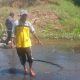 Warga memperlihatkan jalan berlubang dan tergenang air di Pal 6 Desa Sigam, Kotabaru.