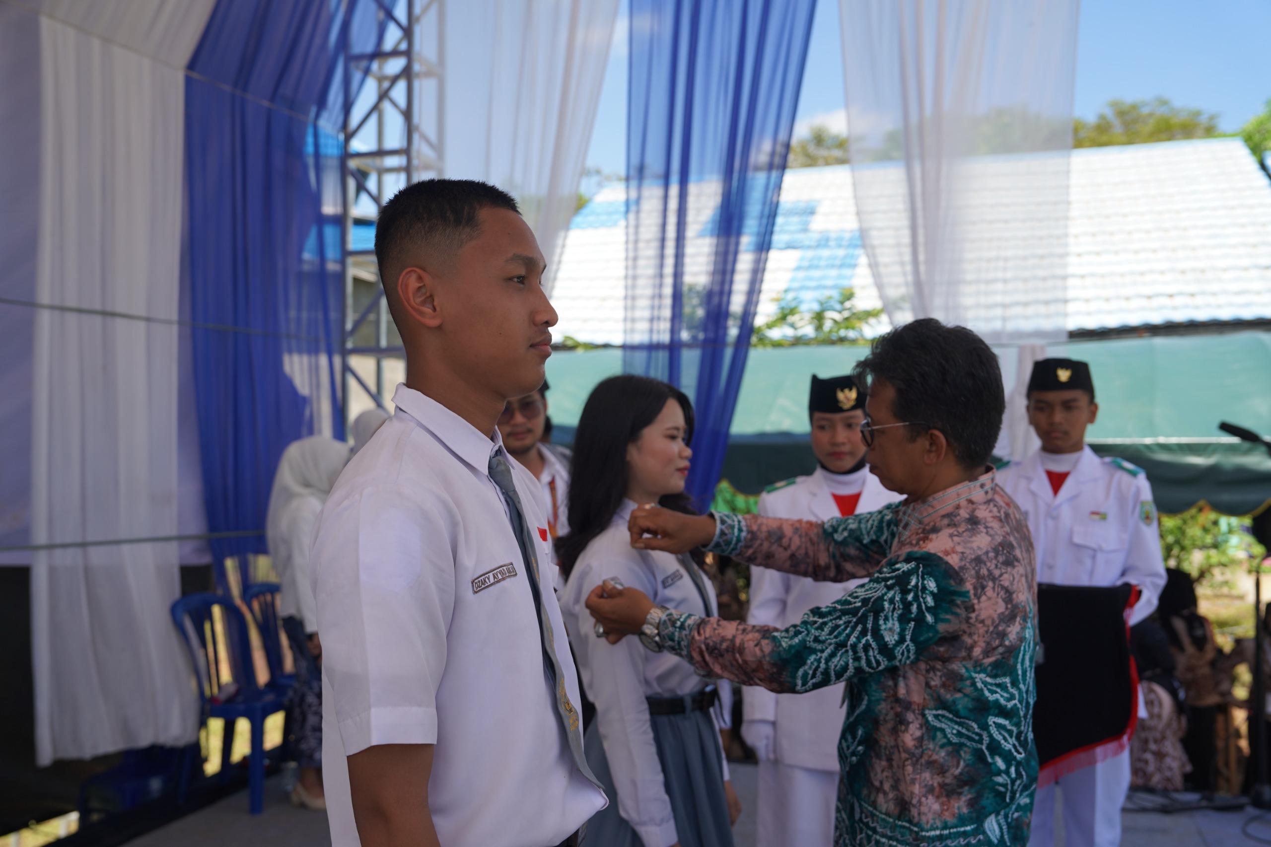 Kadisdikbud Balangan Abiji menyematkan medali kepada siswa pada acara pengukuhan dan pelepasan siswa kelas XII SMAN 2 Paringin.