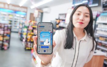 Seorang perempuan menunjukkan aplikasi MyPertamina di ponsel yang kini menyediakan akses rekrutmen kerja Pertamina Talent Candidate.