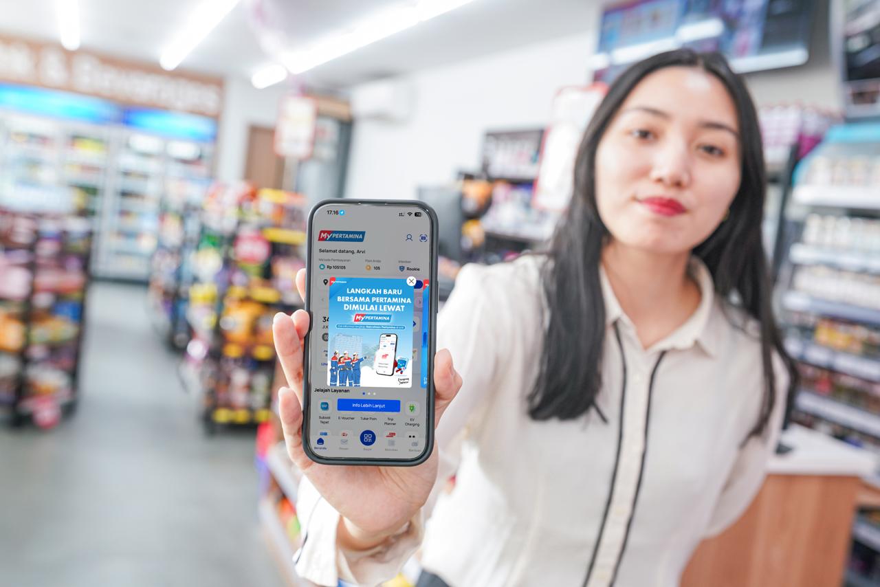 Seorang perempuan menunjukkan aplikasi MyPertamina di ponsel yang kini menyediakan akses rekrutmen kerja Pertamina Talent Candidate.