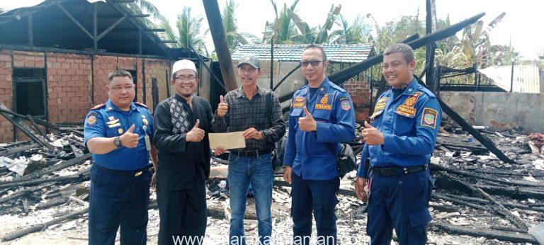 Ketua PWI Tanah Bumbu menyerahkan bantuan kepada wartawan Kotabaru korban kebakaran di lokasi rumah yang hangus terbakar