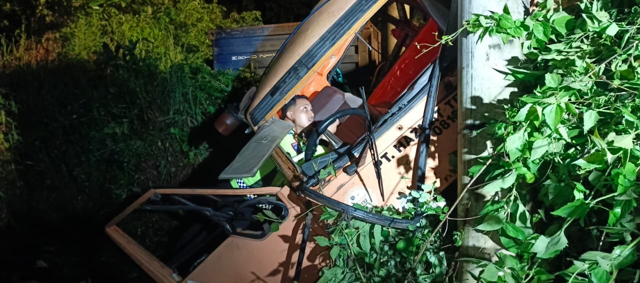 Petugas kepolisian memeriksa mobil trailer yang masuk ke jurang dan membentur tiang listrik di lokasi kecelakaan maut di Pelaihari, Tanah Laut.