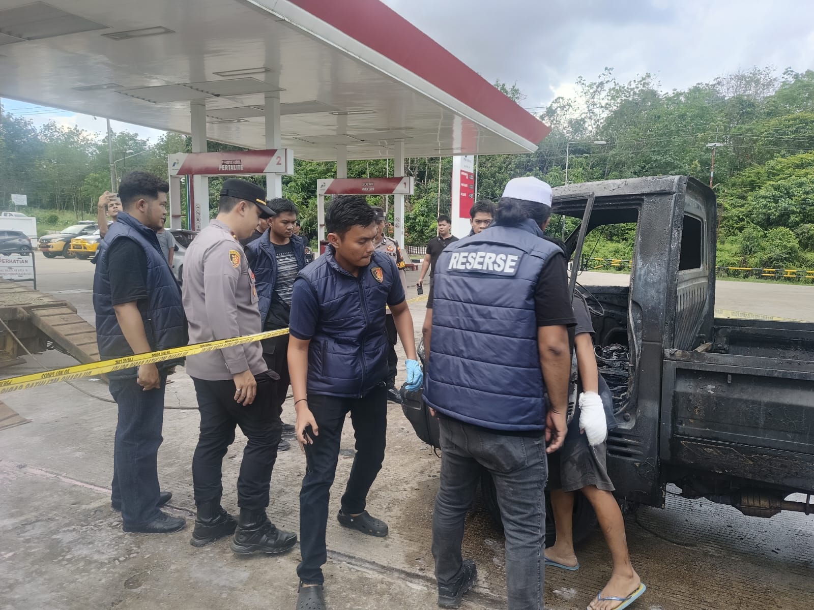 Petugas kepolisian memeriksa mobil pick up yang hangus terbakar di area SPBU Padang Panjang, Tabalong, saat proses olah TKP kebakaran kendaraan.
