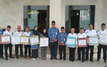 Kepala Bapenda Kotabaru bersama jajaran dan perwakilan kecamatan berfoto sambil memegang dokumen SPPT PBB-P2 Tahun 2026 di depan kantor pemerintahan.