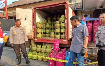 Petugas kepolisian berdiri di depan kendaraan berisi tabung LPG subsidi dan nonsubsidi yang disita dalam kasus dugaan pengoplosan gas LPG di Yogyakarta.