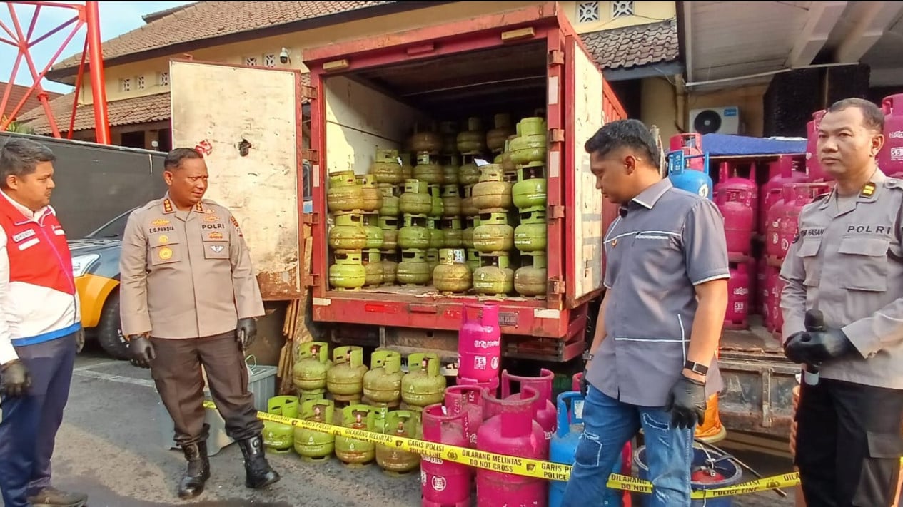 Petugas kepolisian berdiri di depan kendaraan berisi tabung LPG subsidi dan nonsubsidi yang disita dalam kasus dugaan pengoplosan gas LPG di Yogyakarta.