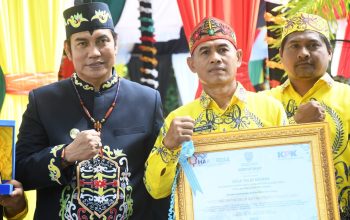 Papan penghargaan desa percontohan anti korupsi untuk Desa Talio Muara.