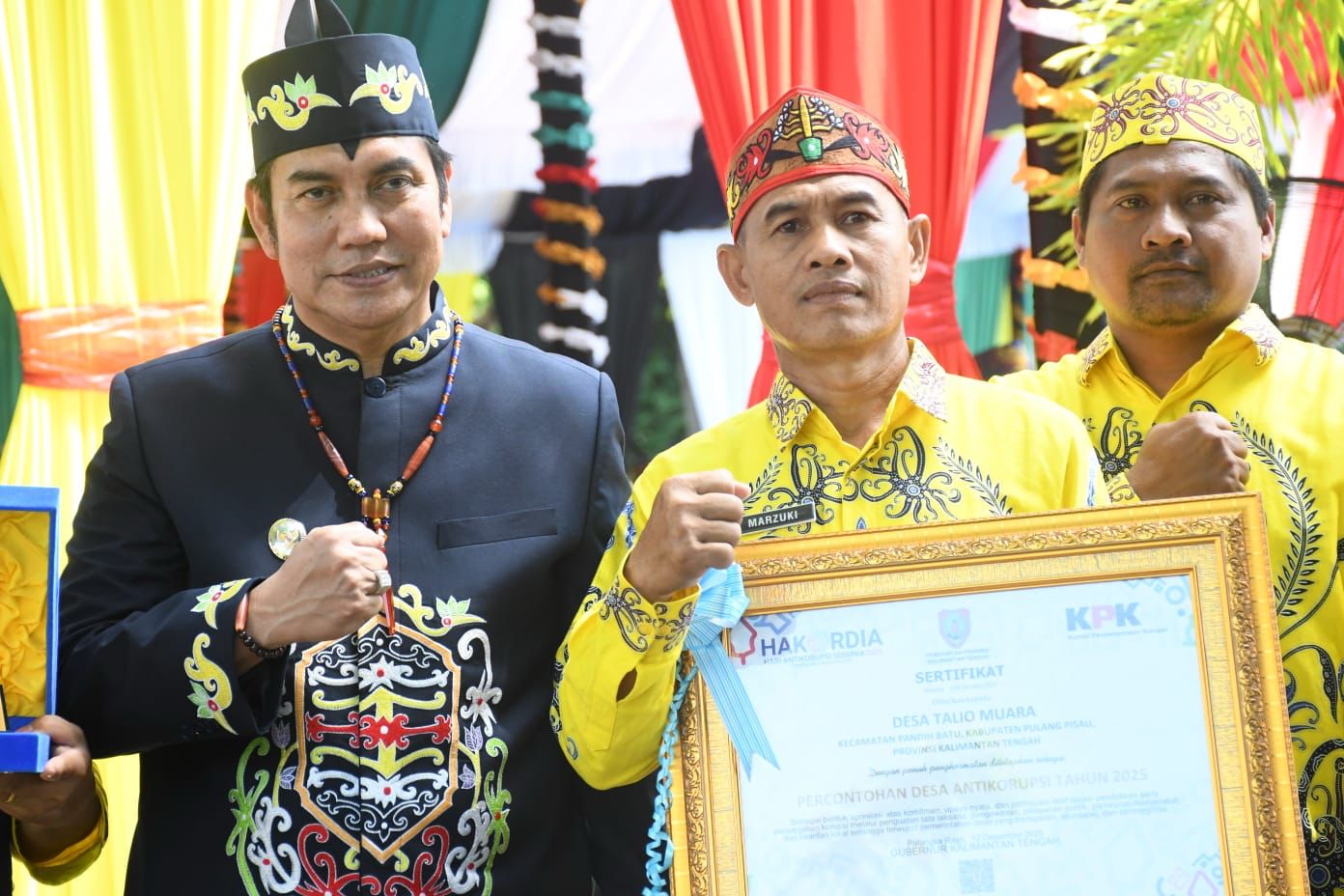 Papan penghargaan desa percontohan anti korupsi untuk Desa Talio Muara.