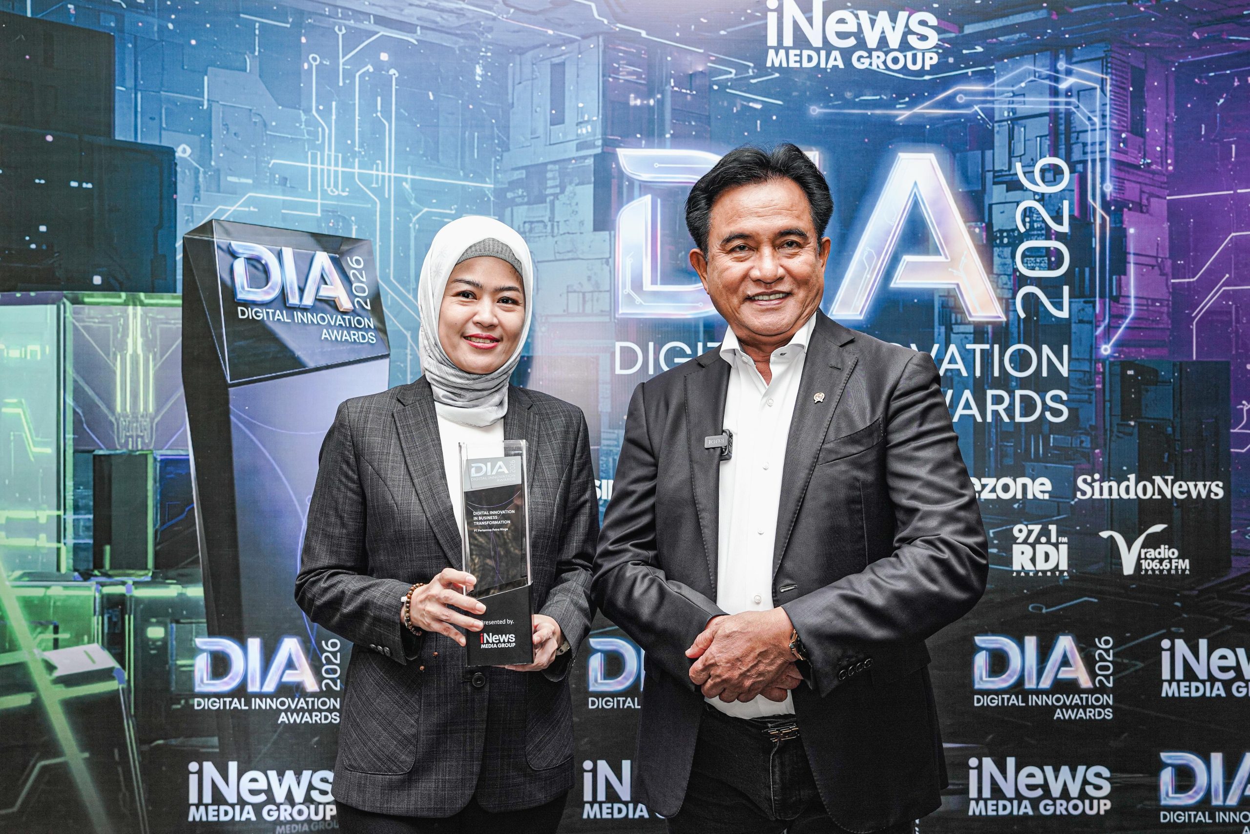 Tenny Elfrida menerima trofi Digital Innovation Awards 2026 dari Menko Yusril Ihza Mahendra.