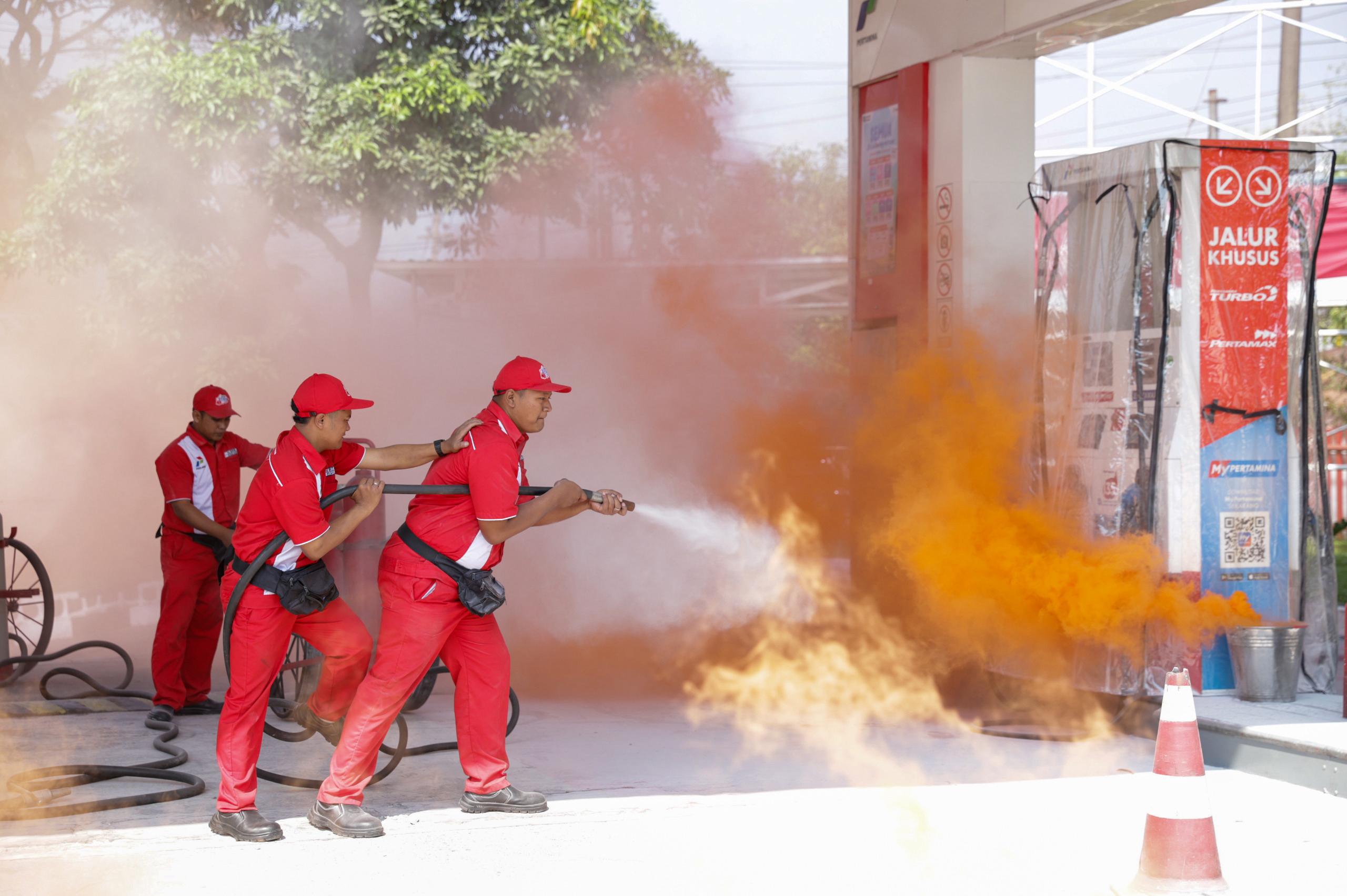 Petugas SPBU dan Damkar memadamkan api dalam simulasi kebakaran di SPBU Langsep Malang.