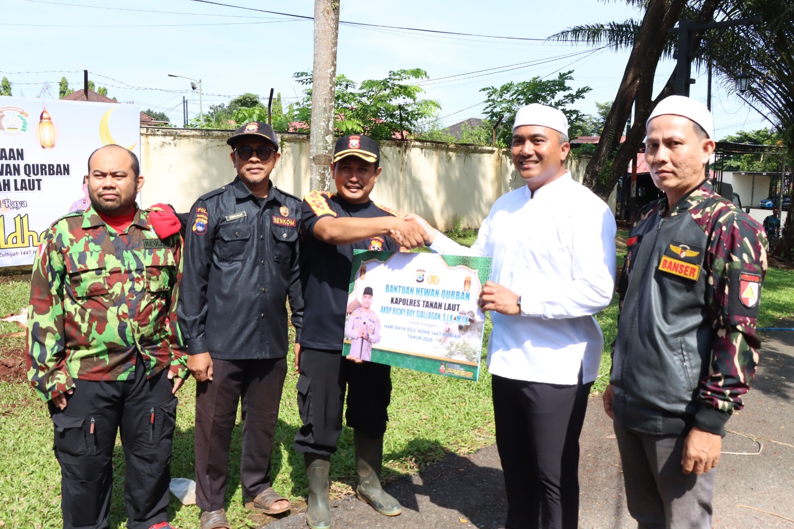 Kapolres Tanah Laut menyerahkan sapi qurban kepada perwakilan penerima.