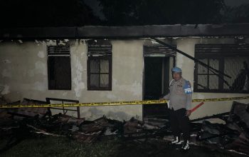 Garis polisi kuning di sekeliling bangunan bekas kebakaran