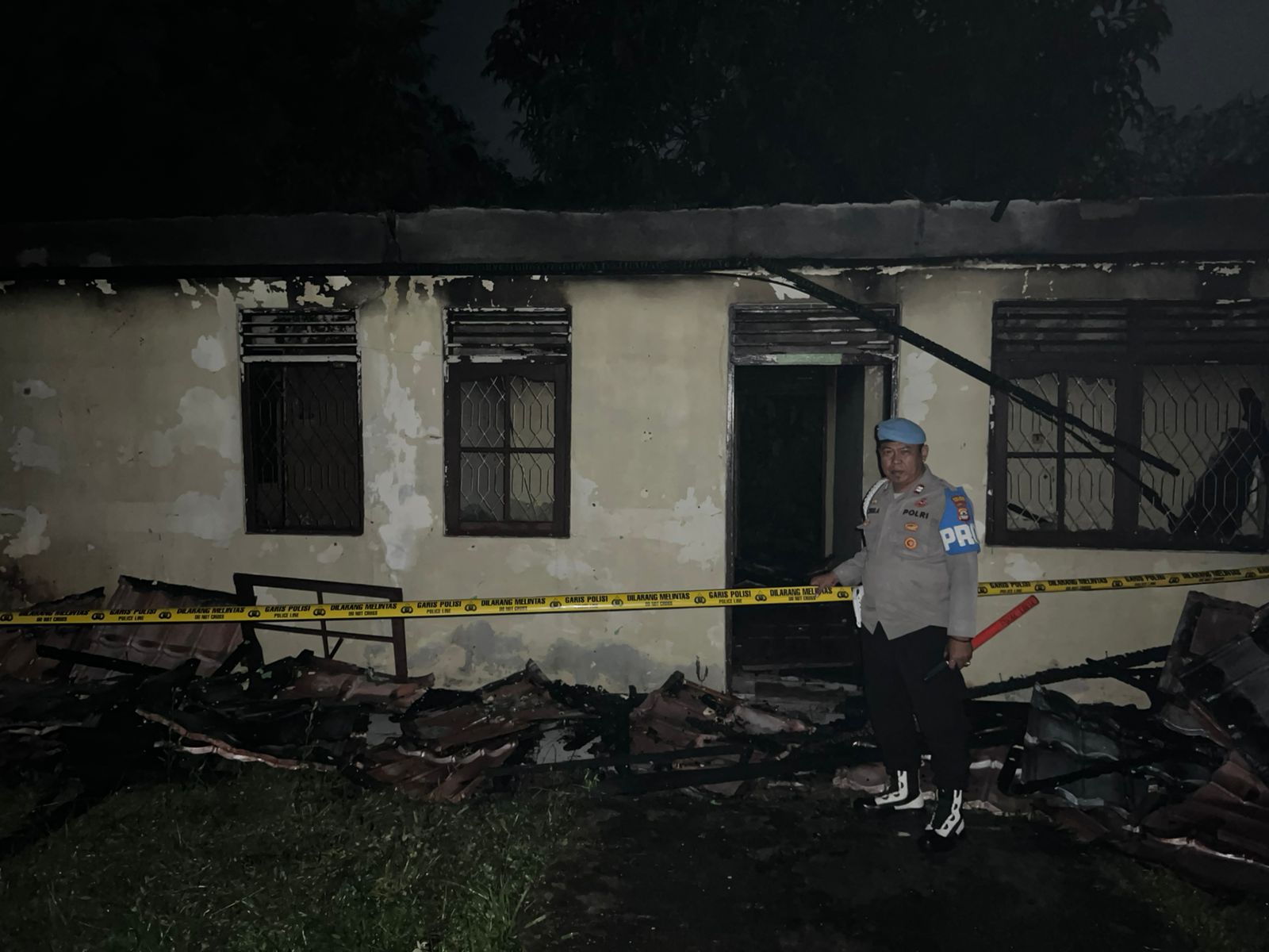 Garis polisi kuning di sekeliling bangunan bekas kebakaran