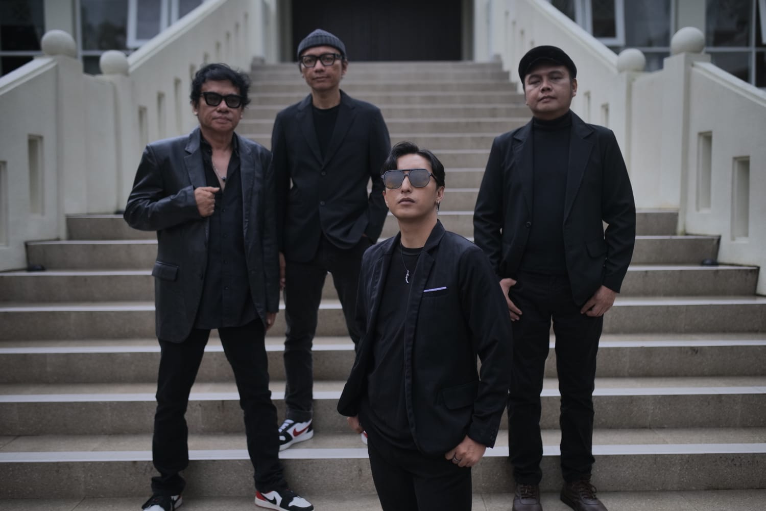 Empat personel band Stinky berpose keren, latar belakang gelap