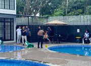 Polisi berseragam mengukur kedalaman kolam renang dengan alat ukur