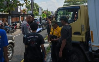 Petugas polisi berada di lokasi kecelakaan mobil Xenia dan truk boks di Ringroad Selatan Bantul yang menyebabkan seorang wanita hamil meninggal dunia.