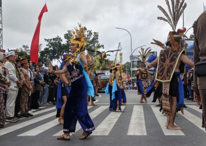 Peserta FBIM 2026 mengenakan busana adat Dayak saat tampil dalam karnaval budaya di Bundaran Talawang, Palangka Raya.