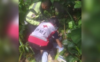 Polisi dan petugas PMI mengevakuasi jenazah korban kecelakaan dari lokasi kejadian.