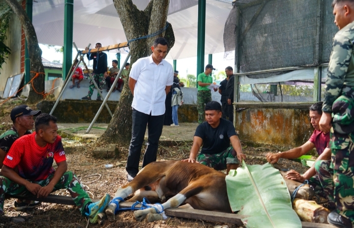 Prajurit Kodim membagikan daging kurban kepada warga sekitar Makodim.