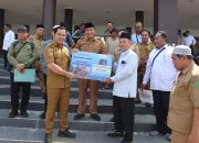 Bupati dan Wakil Bupati Pulang Pisau berdiri di samping sapi kurban di halaman Masjid Agung Ar Raudah.
