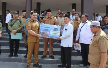 Bupati dan Wakil Bupati Pulang Pisau berdiri di samping sapi kurban di halaman Masjid Agung Ar Raudah.