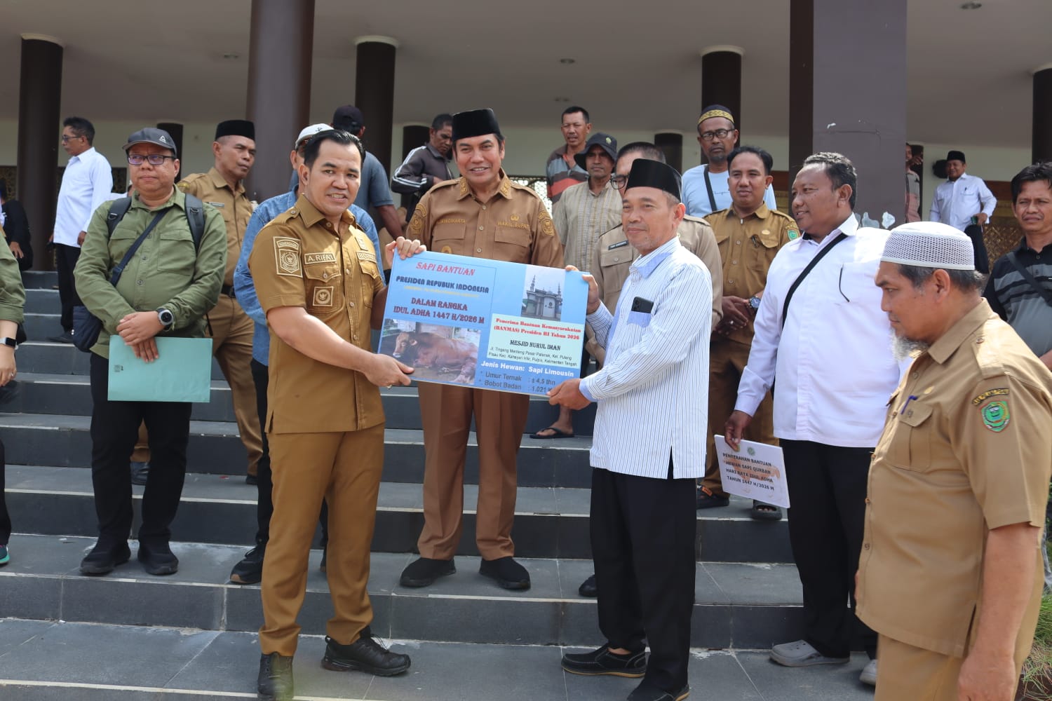Bupati dan Wakil Bupati Pulang Pisau berdiri di samping sapi kurban di halaman Masjid Agung Ar Raudah.