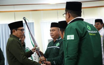 Pengurus menyerahkan bendera Pataka ISNU kepada Ketua PC ISNU yang baru dilantik.