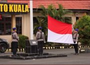 Anggota polres Batola membentangkan bendera merah putih