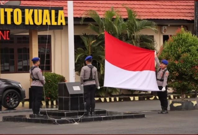 Anggota polres Batola membentangkan bendera merah putih